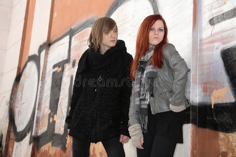 Meisje en jonge mens tegen muur van graffiti stock foto's Meisje en jonge mens tegen muur van graffiti stock foto's