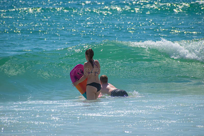 Daytona Beach Florida. July 07, 2019 Girl and boy with surfboard enjoying waves at Main Street Pier area. 3. Daytona Beach Florida. July 07, 2019 Girl and boy with surfboard enjoying waves at Main Street Pier area. 3