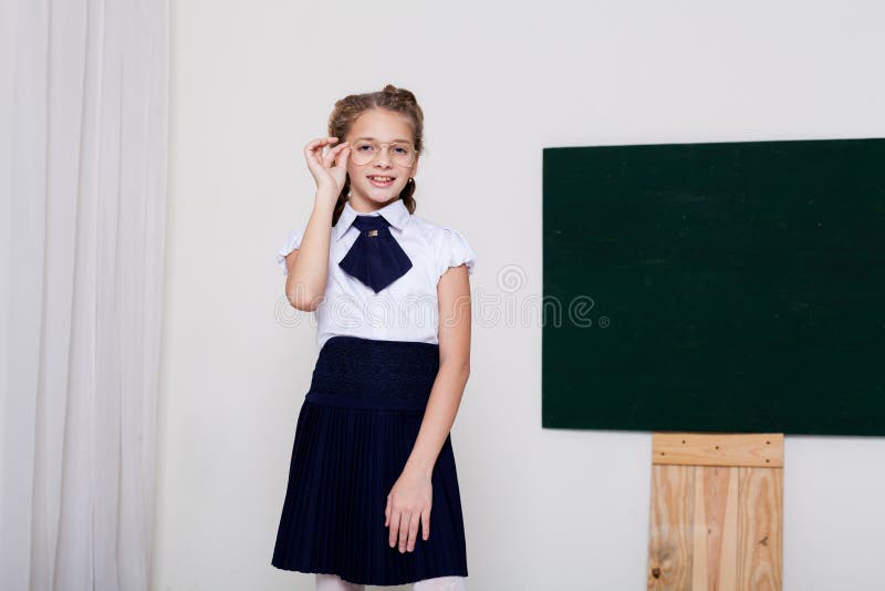 Meisje in glazen bij het Bord in een klassenles royalty-vrije stock foto Meisje in glazen bij het Bord in een klassenles royalty-vrije stock foto