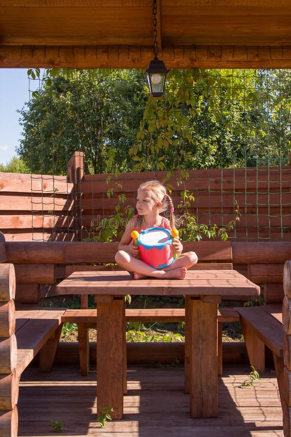 Meisje het spelen met een trommel in houten as stock foto Meisje het spelen met een trommel in houten as stock foto