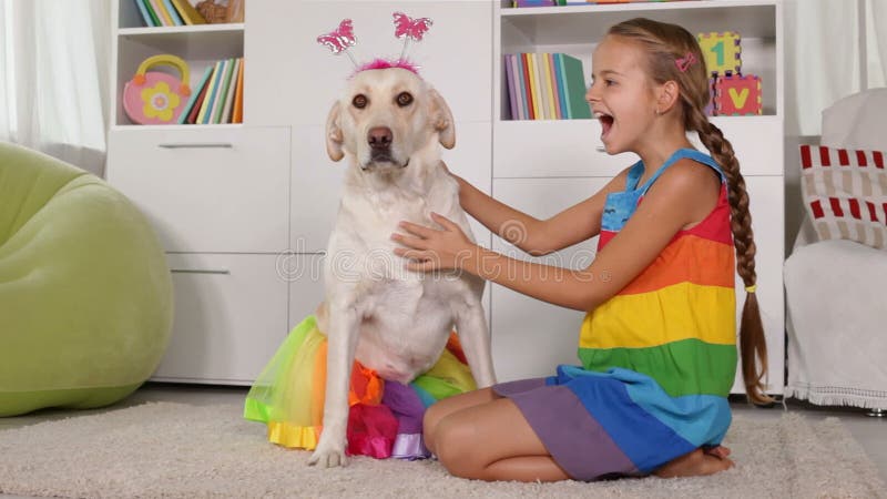 Meisje het spelen met hond die - zich gelijk kleden