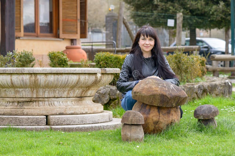 Meisje het stellen dichtbij houten paddestoelen royalty-vrije stock afbeeldingen Meisje het stellen dichtbij houten paddestoelen royalty-vrije stock afbeeldingen