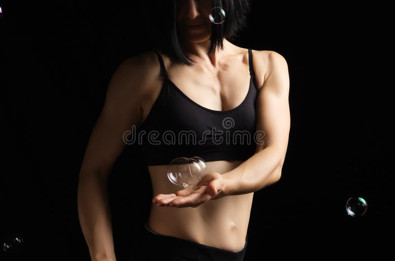 Meisje met een sportfiguur en spieren houdt een zeepbel in haar palm royalty-vrije stock foto Meisje met een sportfiguur en spieren houdt een zeepbel in haar palm royalty-vrije stock foto