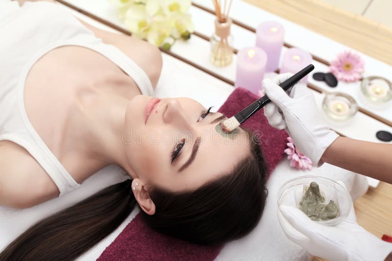 Girl with facial mask lying in beauty health spa center. Girl with facial mask lying in beauty health spa center.