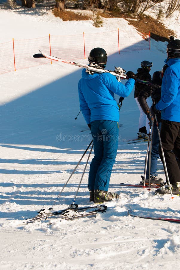 Meisje met helm en ski op schouder na het ski?en in een zonnige dag stock fotografie Meisje met helm en ski op schouder na het ski?en in een zonnige dag stock fotografie