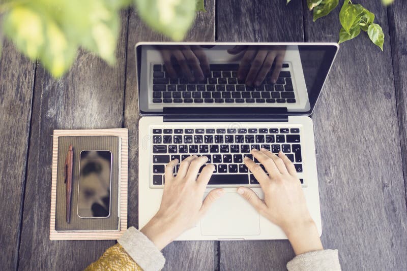 Girl with laptop, cell phone and diary on wooden table outdoor, close up. Girl with laptop, cell phone and diary on wooden table outdoor, close up