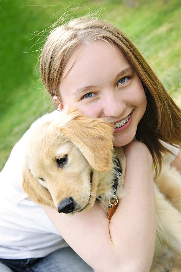 Portrait of smiling teenage girl holding golden retriever puppy. Portrait of smiling teenage girl holding golden retriever puppy