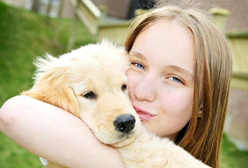 Portrait of smiling teenage girl holding golden retriever puppy. Portrait of smiling teenage girl holding golden retriever puppy