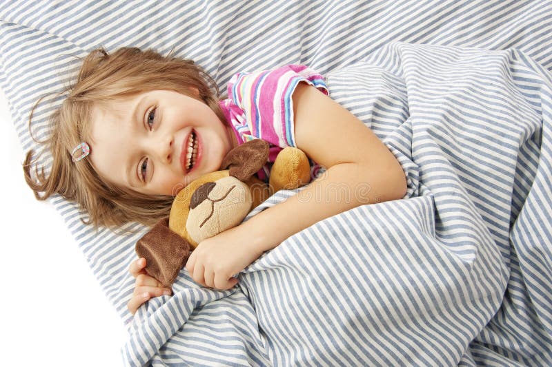 Meisje met stuk speelgoed in het bed stock foto Meisje met stuk speelgoed in het bed stock foto