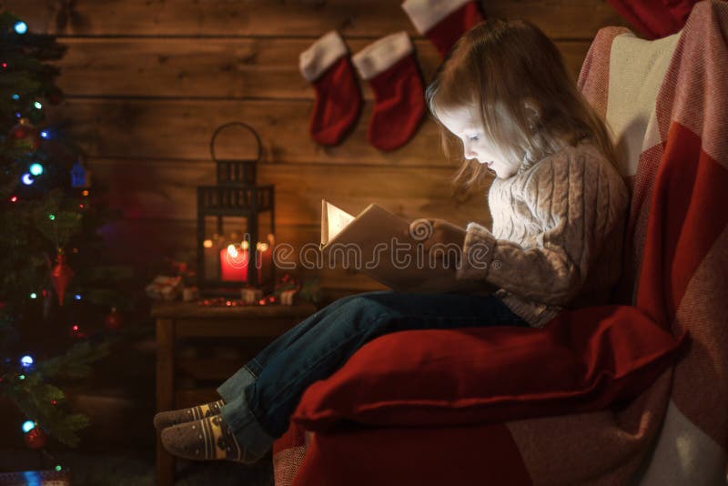 Meisje thuis met een Kerstmisboom, giften die een boekzitting lezen royalty-vrije stock afbeelding Meisje thuis met een Kerstmisboom, giften die een boekzitting lezen royalty-vrije stock afbeelding