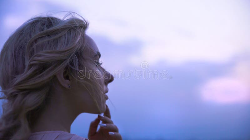 Meisje wat betreft haar lippen, die over de geliefde mens denken die, droevig afstand onderzoeken stock foto Meisje wat betreft haar lippen, die over de geliefde mens denken die, droevig afstand onderzoeken stock foto