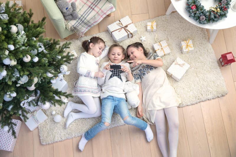Meisjes onder de Kerstboom stock fotografie Meisjes onder de Kerstboom stock fotografie