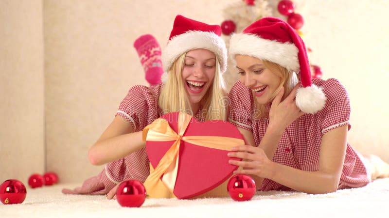 Meisjesvrienden met giftemoties Nieuwe yearn stellen en de voorbereidingsgift voor Vrolijke Kerstmis en Gelukkig Nieuwjaar best