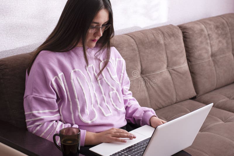 Meisjeszitting thuis op laaglaptop royalty-vrije stock afbeeldingen Meisjeszitting thuis op laaglaptop royalty-vrije stock afbeeldingen