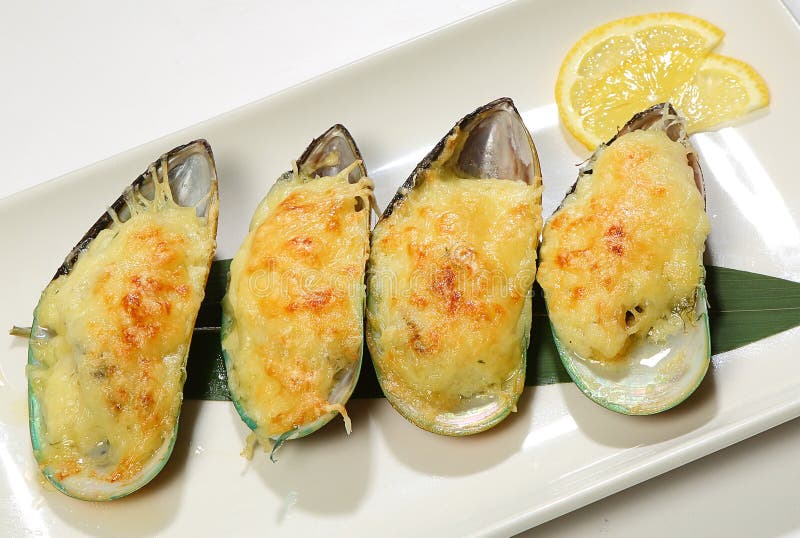 Mejillones del Gigante-kiwi debajo de la corteza del queso con el limón foto de archivo Mejillones del Gigante-kiwi debajo de la corteza del queso con el limón foto de archivo
