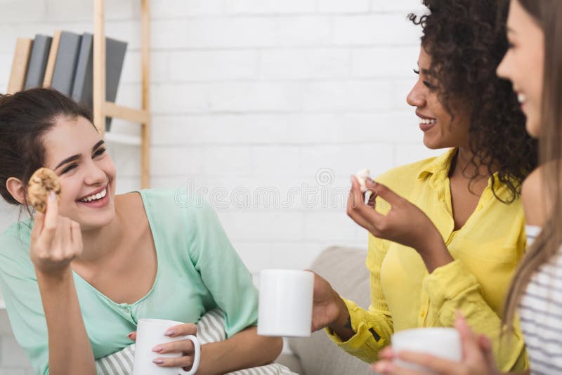Mejores amigos que comen las galletas y que beben té en casa fotografía de archivo libre de regalías Mejores amigos que comen las galletas y que beben té en casa fotografía de archivo libre de regalías