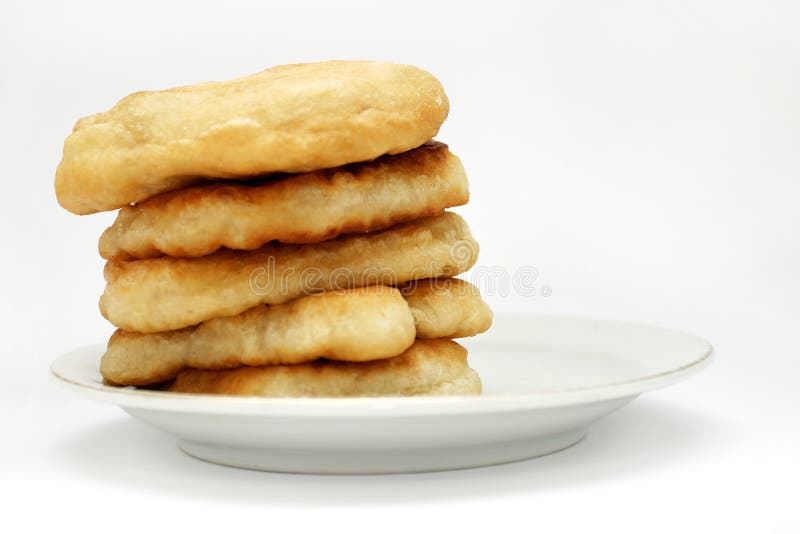 Mekitsa (or mekica): batter fried in deep oil. In dish; Dough with sodium and water or with milk (or yoghourt) and eggs. Traditional cuisine; Isolated on white;. Mekitsa (or mekica): batter fried in deep oil. In dish; Dough with sodium and water or with milk (or yoghourt) and eggs. Traditional cuisine; Isolated on white;