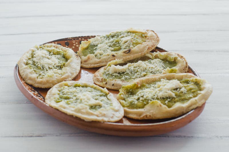 Meksykańscy sopes z kraciastym serem i zieleń salsa, meksykański karmowy korzenny w Mexico zdjęcie royalty free Meksykańscy sopes z kraciastym serem i zieleń salsa, meksykański karmowy korzenny w Mexico zdjęcie royalty free