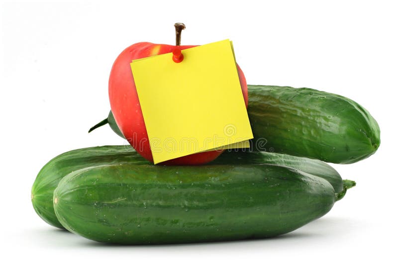 Cucumbers apple and blank yellow note against white background. Cucumbers apple and blank yellow note against white background