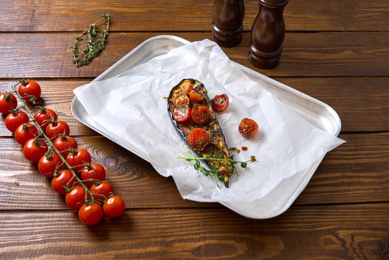 Melanzana al forno con pomodori ciliegia ed erbe aromatiche e nutrienti fotografia stock libera da diritti