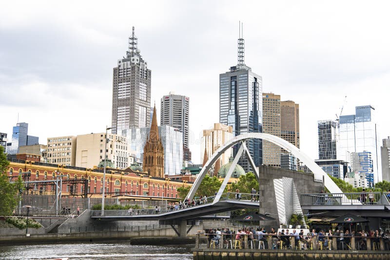 Evan Walker Bridge - modern architecture including bar and restaurant over Yarra River. In the background you can see the Central Station and Visitor Center, St. Paul`s Cathedral and skyscrapers. Evan Walker Bridge - modern architecture including bar and restaurant over Yarra River. In the background you can see the Central Station and Visitor Center, St. Paul`s Cathedral and skyscrapers