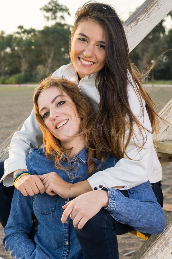 Meninas Bonitas Que Relaxam Em Escadas De Madeira Foto de Stock - Imagem de  beleza, estudantes: 49400678