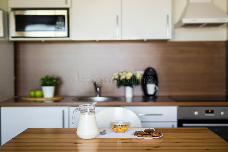 Melk, cornflakes en koekjes in moderne keuken stock fotografie Melk, cornflakes en koekjes in moderne keuken stock fotografie