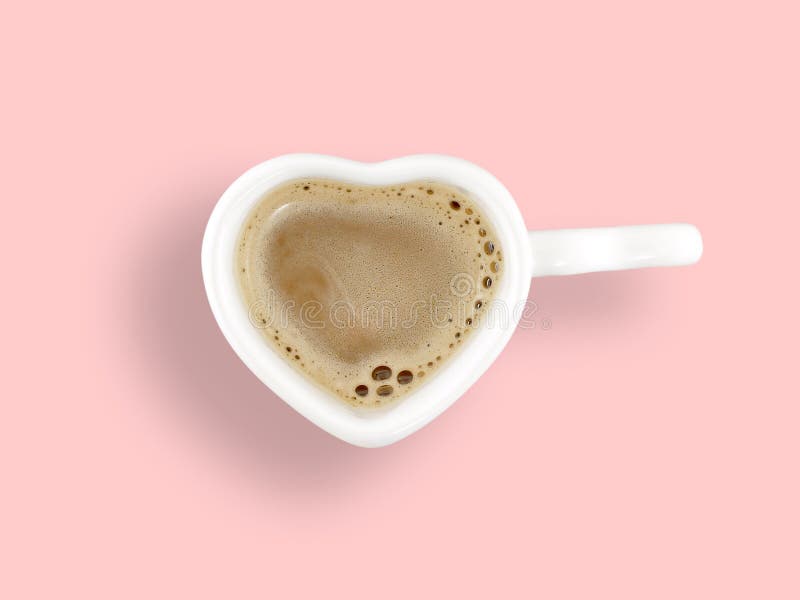 Melkkoffie in witte ceramische de koffiekop van de hartvorm op pastelkleur roze achtergrond royalty-vrije stock foto Melkkoffie in witte ceramische de koffiekop van de hartvorm op pastelkleur roze achtergrond royalty-vrije stock foto