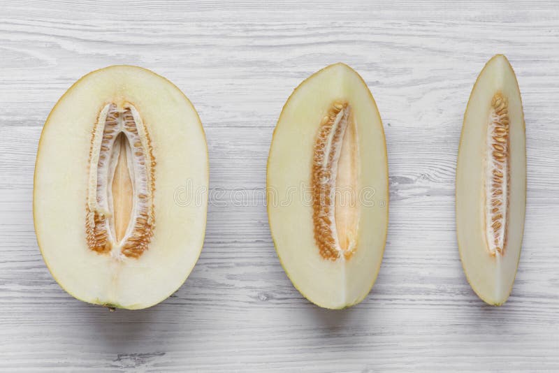 Melon slices on white wooden background, top view. From above, flat lay.