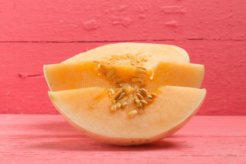 melone ( sunlady) fetta mezzo sul rosa di legno fotografia stock melone ( sunlady) fetta mezzo sul rosa di legno fotografia stock