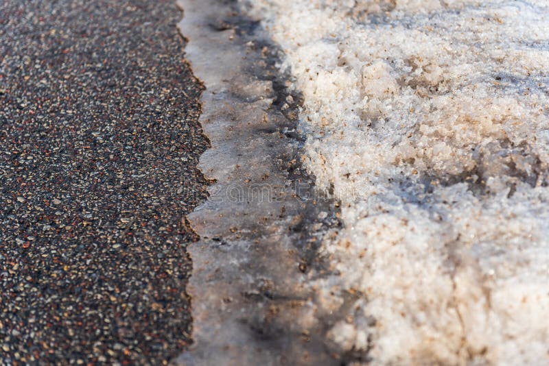 Melting Snow on the Asphalt Road. Spring is Approaching Stock Photo