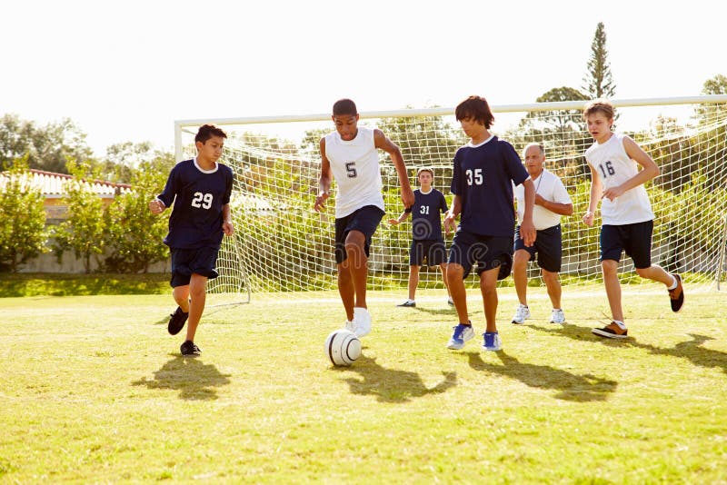 Membri di calcio maschio della High School che gioca partita immagine stock libera da diritti Membri di calcio maschio della High School che gioca partita immagine stock libera da diritti