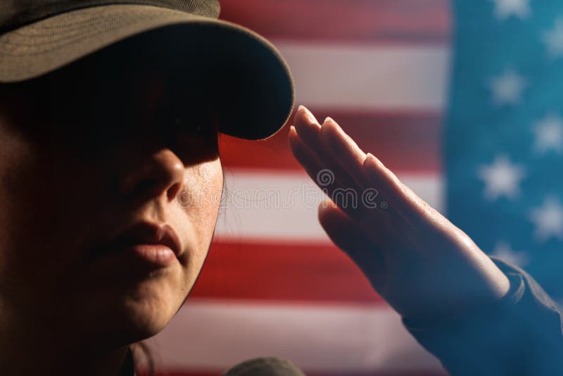 Memorial day. A female soldier in uniform salutes against the background of the American flag. Close-up portrait. Copy space. The