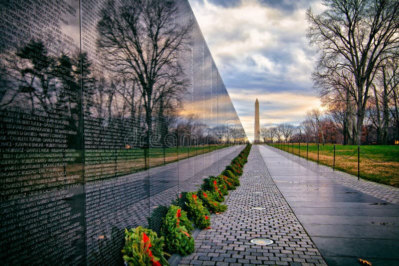 Memorial de guerra do vietname com Washington Monument no nascer do sol, Washington, C.C., EUA fotografia de stock Memorial de guerra do vietname com Washington Monument no nascer do sol, Washington, C.C., EUA fotografia de stock
