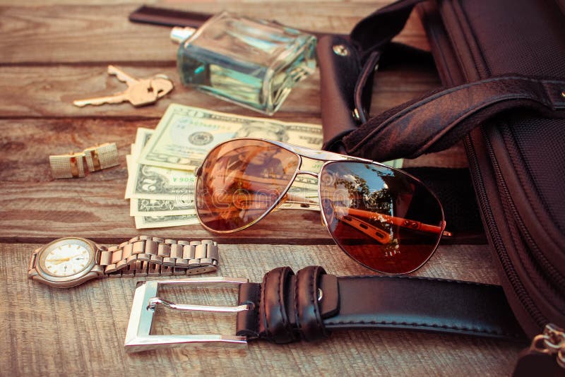 Men accessories sunglasses, bag, money, wrist watch, cufflinks, comb, strap, keys, perfume on the old wood background. Toned image. Button clasp stock images, royalty-free photos and pictures