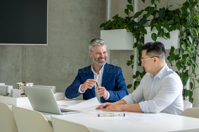 Men architects working on construction plans, engineers discussing on project in office. stock photography