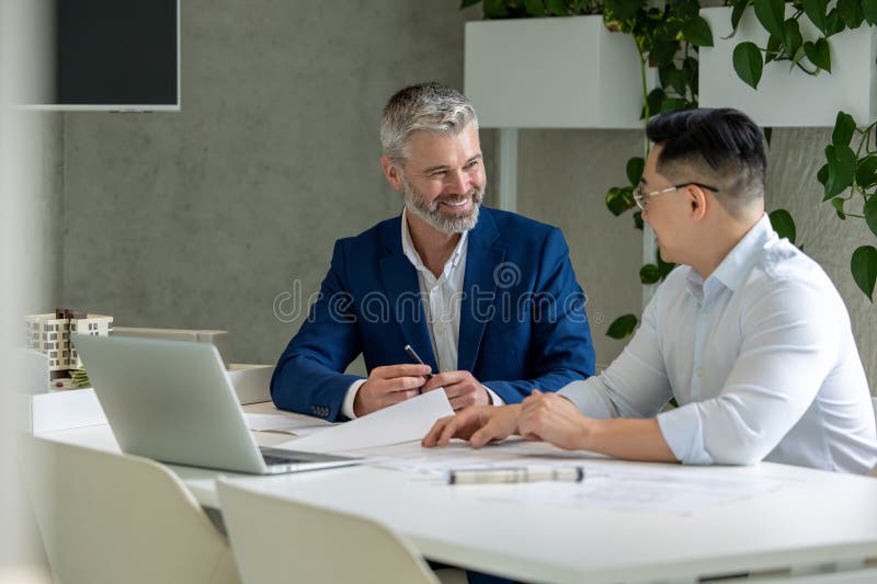 Men architects working on construction plans, engineers discussing on project in office. royalty free stock image