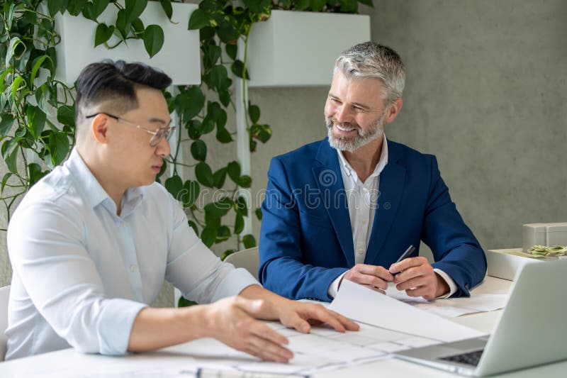Men architects working on construction plans, engineers discussing on project in office. stock images