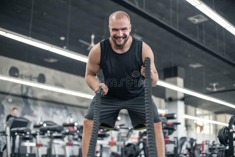 Men with battle rope battle ropes exercise in the fitness gym. CrossFit stock image Men with battle rope battle ropes exercise in the fitness gym. CrossFit stock image