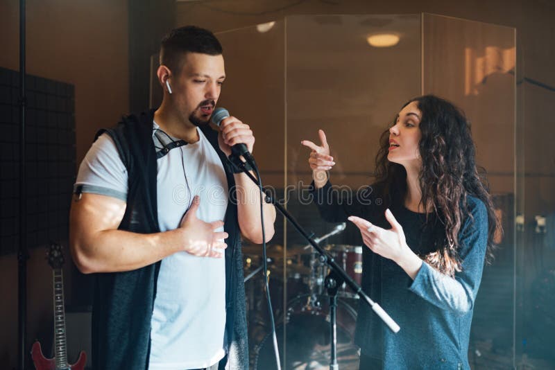 A man does chanting with a teacher in vocal lesson pointing to the correct breathing in the chest