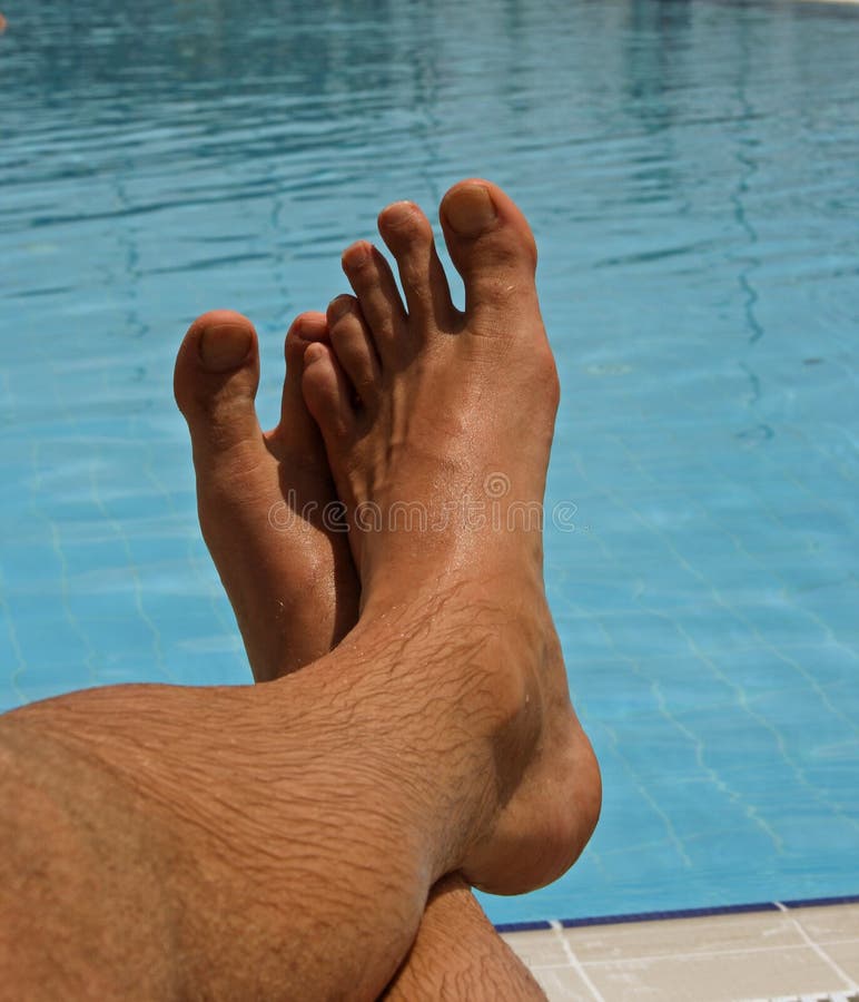 A men's feet at the swimming pool. A men's feet at the swimming pool.