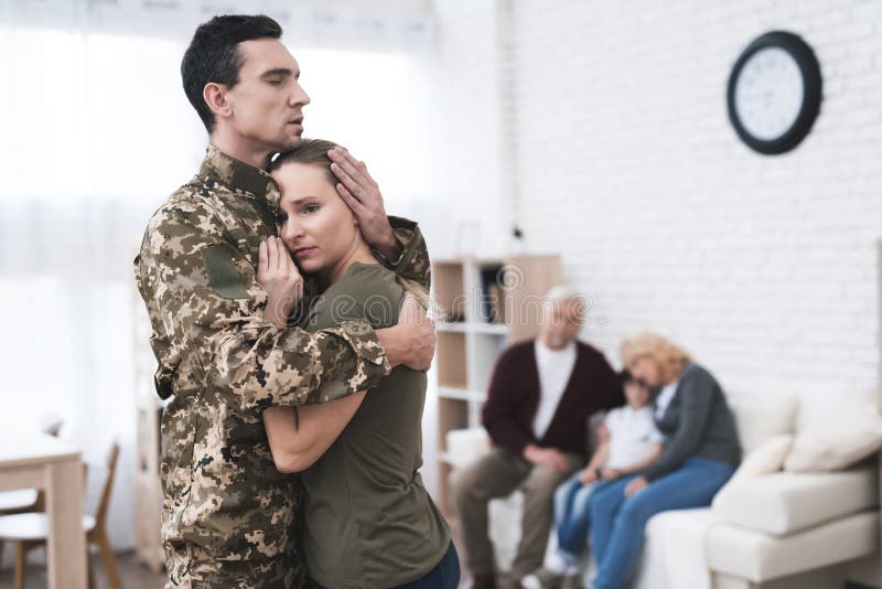 A men goes to military service. He says goodbye to his family and parents. They are sad and embrace. A men goes to military service. He says goodbye to his family and parents. They are sad and embrace.