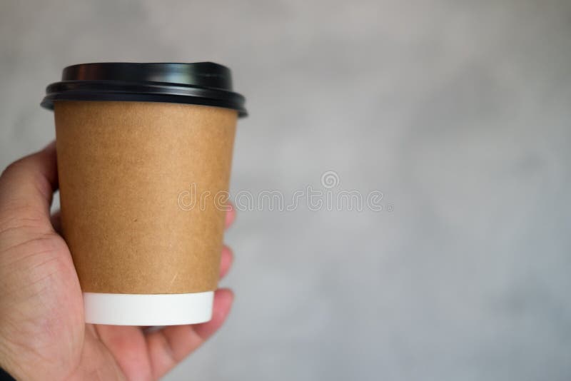 Men hand holds out a paper cup of coffee to take away