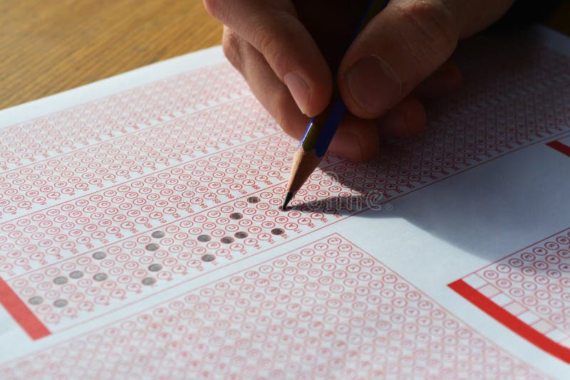 Hand with pencil filling out answers on exam test answer sheet stock image Hand with pencil filling out answers on exam test answer sheet stock image