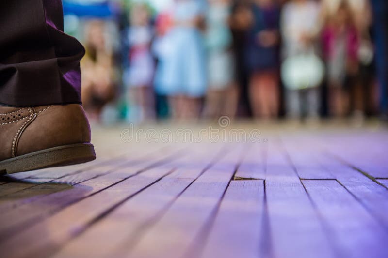 Men`s foot in the shoes and dance floor