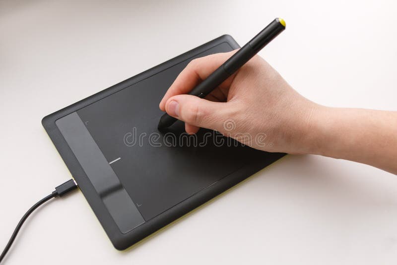 Men`s hand draws on a graphics tablet using a stylus stock images Men`s hand draws on a graphics tablet using a stylus stock images
