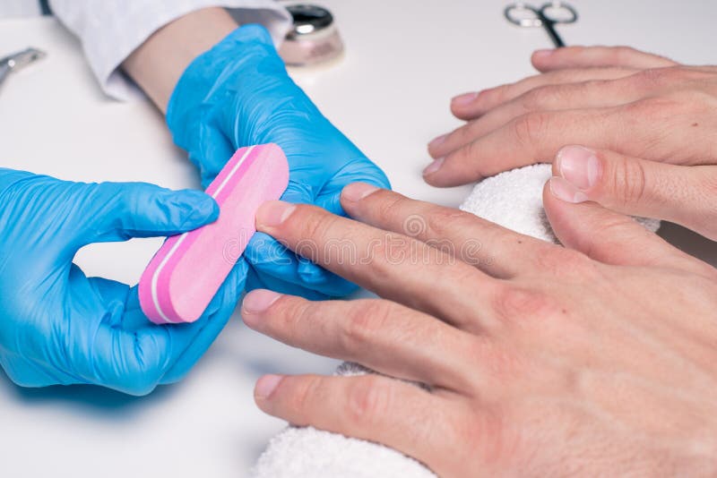 Men`s Manicure. Cosmetologist in Rubber Gloves File Nails on Male Hands.  Stock Photo - Image of finger, body: 118408528