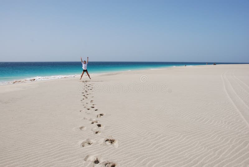 Men on sandy beach - blue ocean and sky royalty free stock images