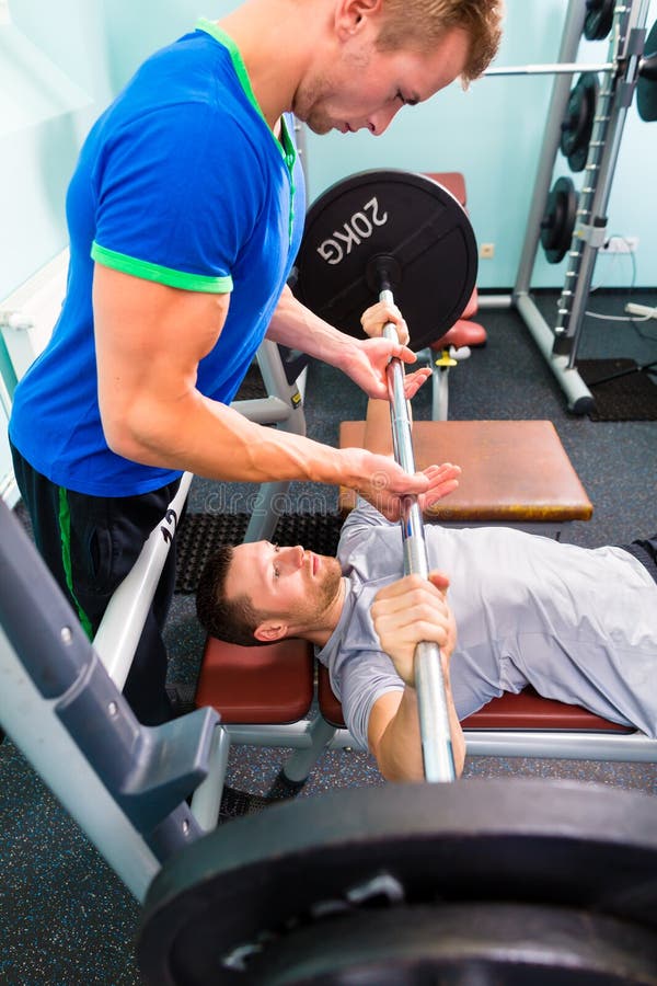 Men in sport gym training with barbell for fitness