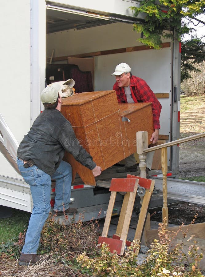 Dos hombres descargar pesado muebles conmovedor.